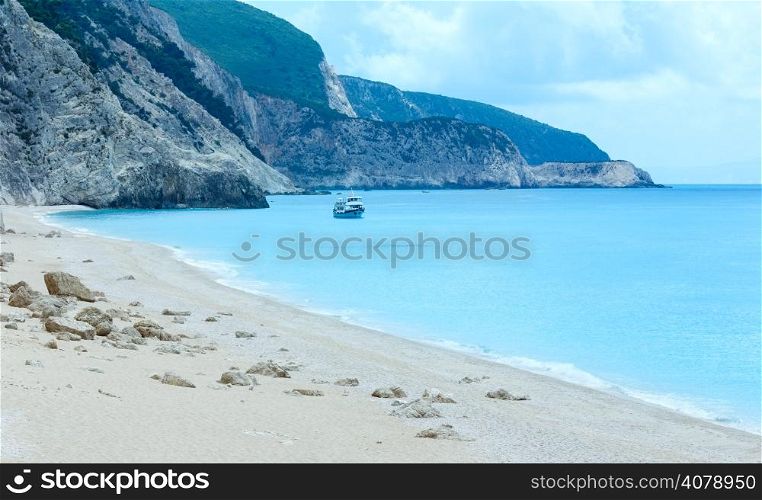 Summer view of Egremni beach (Lefkada, Greece) and ship on water.