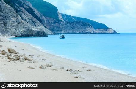 Summer view of Egremni beach (Lefkada, Greece) and ship on water.