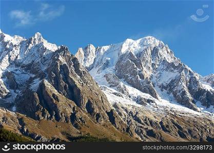 Summer view of snowcapped peaks in an alpine valley. Gran Jourasses (Mont Blanc massif), Val Veny, Courmayeur, Italy.