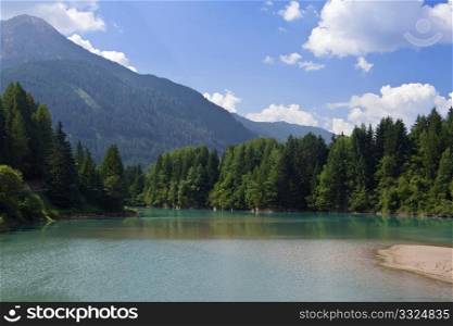 Summer view of Soraga lake in Fassa valley, Italy