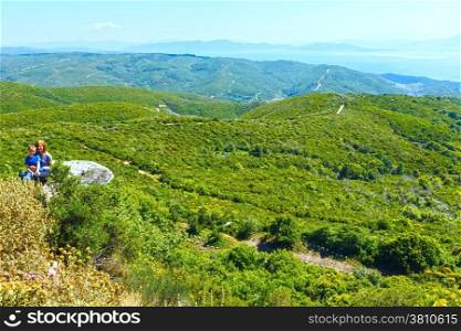 Summer view of the Aegean Sea from the top of the hill and family on big stone (Greece)