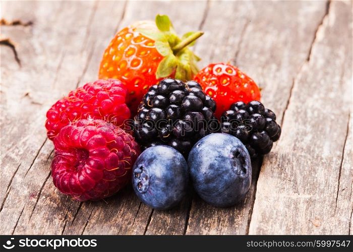 Summer wild berries over shabby wooden background. Berries close up