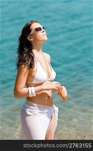 Summer woman in bikini alone on beach sunbathing
