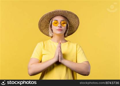 Summer woman praying for peace, love, harmony on yellow background. Girl begs God to save people, children. Gratitude, religion concept. High quality photo. Summer woman praying for peace, love, harmony on yellow background. Girl begs God to save people, children. Gratitude, religion concept.
