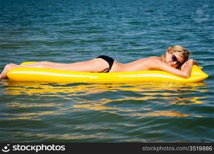 Summer woman sunbathe on water floating mattress sunny day