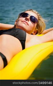 Summer woman sunbathing relax on water floating mattress sunny day