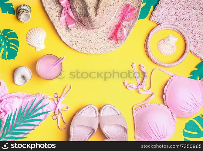 Summer yellow background with pink bikini, straw hat, sunglasses, sandals with cocktail , seashells , tropical palm leaves. Summer female fashion outfit. Girls beach accessories. Top view, frame