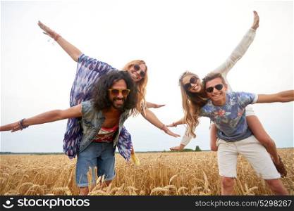 summer, youth culture and people concept - happy young hippie friends having fun on cereal field. happy hippie friends having fun on cereal field