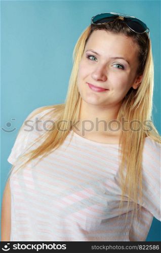 Summeral outfit ideas, fashion, clothes concept. Blonde woman wearing sunglasses and summer clothing. Studio shot on blue background.. Blonde woman wearing sunglasses and summer clothing