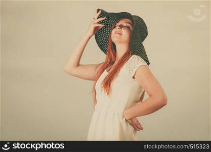 Summertime outfit accessories concept. Happy redhead woman wearing big black sun hat.. Happy redhead woman wearing big black sun hat