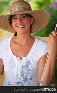 Summery portrait of a woman in a straw hat relaxing in the garden
