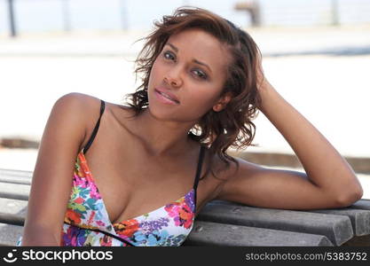 Summery woman sitting on a bench