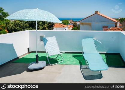 Sun beds and umbrellas on terrace in a luxury summer resort with Atlantic sea view in Cascais, Portugal.. Sun beds and umbrellas on terrace in a luxury summer resort with Atlantic sea view in Cascais, Portugal