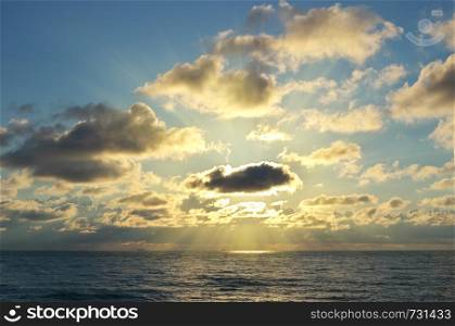 Sun behind the clouds on sea. Compositio of nature.