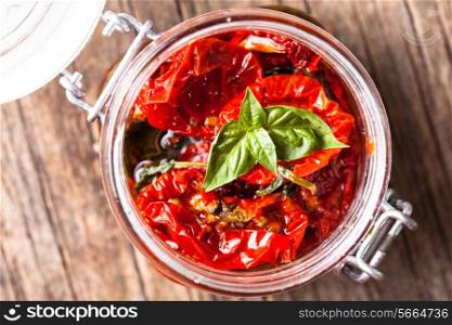 sun dried tomatoes in a glass jar with fresh basil