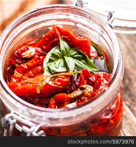 sun dried tomatoes in a glass jar with fresh basil. sun dried tomatoes