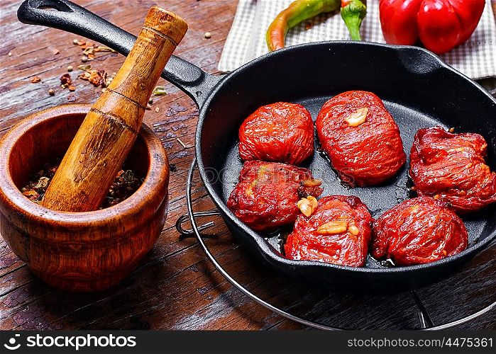 Sun-dried tomatoes in the pan. Spicy dish with sun-dried tomatoes and hot spices