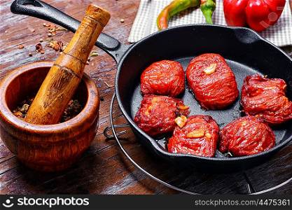 Sun-dried tomatoes in the pan. Spicy dish with sun-dried tomatoes and hot spices