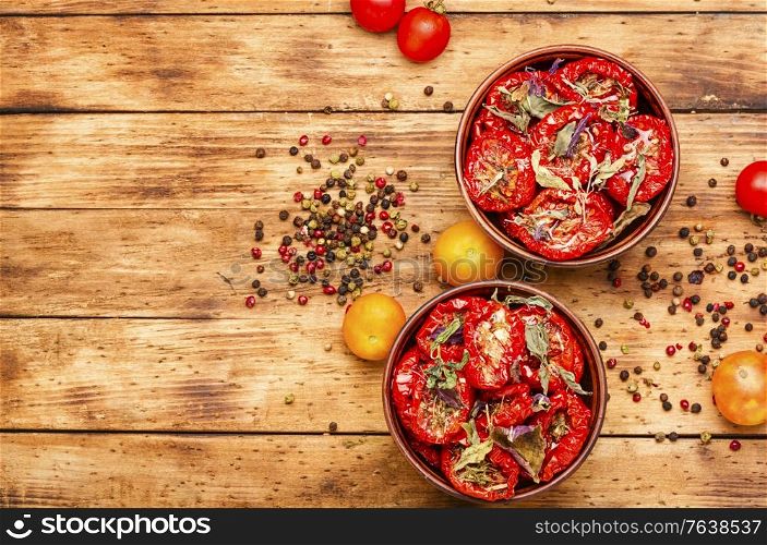 Sun dried tomatoes with herbs and spices. Bowl of sun dried tomatoes