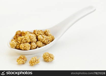 sun-dried white mulberry berries on a ceramic tablespoon