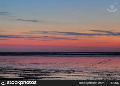 sun going down over mudflat at the german north sea coast. sundown over mudflat