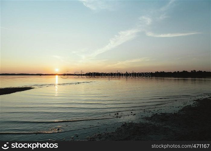 Sun hiding behind the horizon in the lake of chiemsee