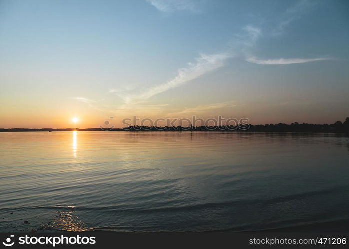 Sun hiding behind the horizon in the lake of chiemsee