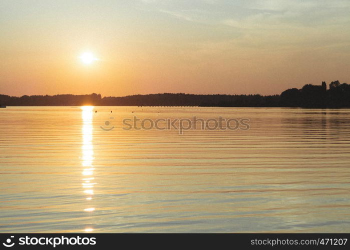 Sun hiding behind the horizon in the lake of chiemsee