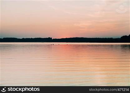 Sun hiding behind the horizon in the lake of chiemsee