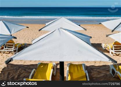 Sun loungers and a beach umbrella on a deserted beach perfect vacation concept.. Sun loungers and a beach umbrella on a deserted beach perfect vacation concept