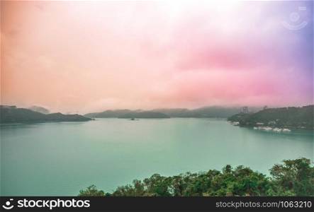 Sun Moon Lake landscape view with pastel rainbow sky in rainy day.