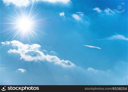 Sun on the blue sky. Sun with sun rays on the blue sky with clouds