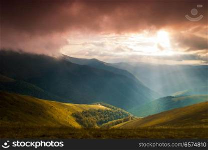Sun rays over valley. Wonderful panorama of the mountains. The sunbeams penetrates through the clouds in the middle of the valley.. Sun rays over valley