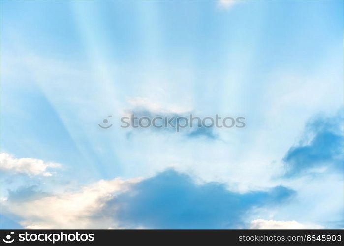Sun rays shining through cloud on blue sunset sky. Sun rays shining through cloud