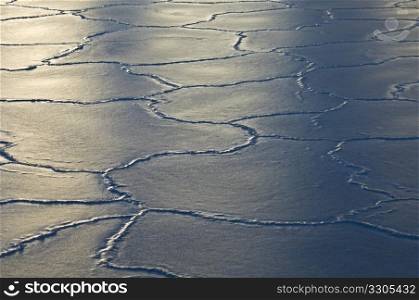 sun reflecting on ice floes with many cracks