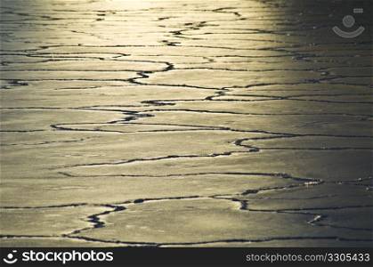 sun reflecting on ice floes with many cracks