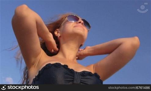 Sun reflection in sunglasses of young girl on the beach