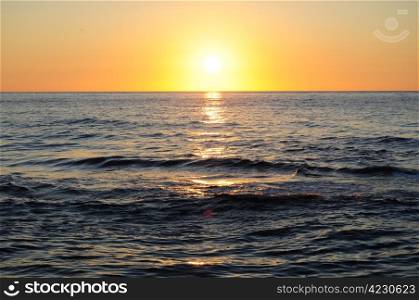 Sun rising above the sea, reflects in the water