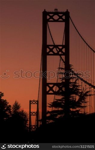 Sun Setting Behind Bridge And Trees