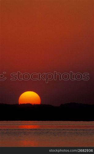 Sun setting behind lake and mountains, Bavaria