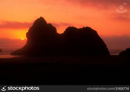 Sun Setting Behind Rocks On The Oregon Coast