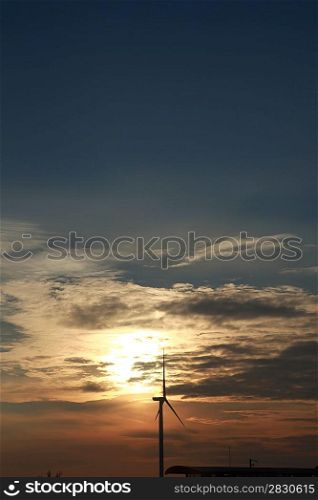Sun setting behind wind farm