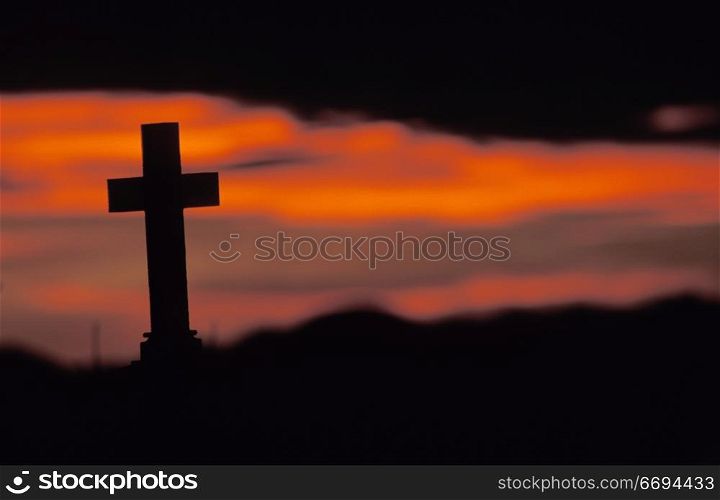 Sun Setting on Lone Cross in Graveyard