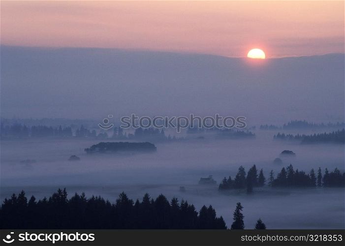 Sun Setting over Misty Mountains