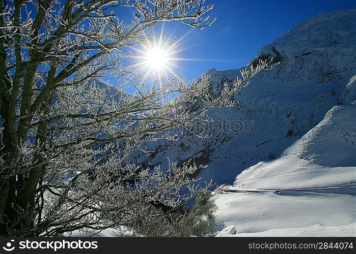 Sun shining onto snow covered mountain