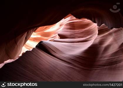 Sun shining through a crack in a red rock slot canyon.