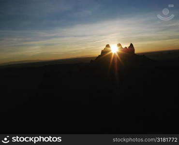 Sun shining through butte at Monument Valley.