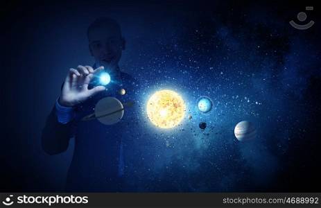 Sun system. Young businessman catching planet of sun system