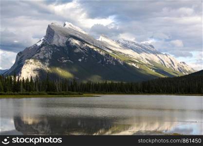 Sunbeam makes high mountain reflect in lake