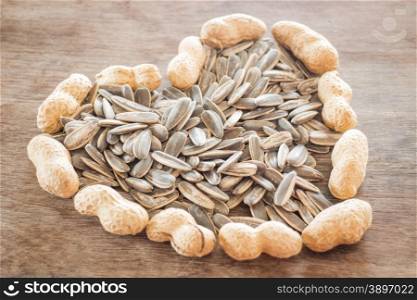 Sunflower and peanut seeds on weathered wood, stock photo